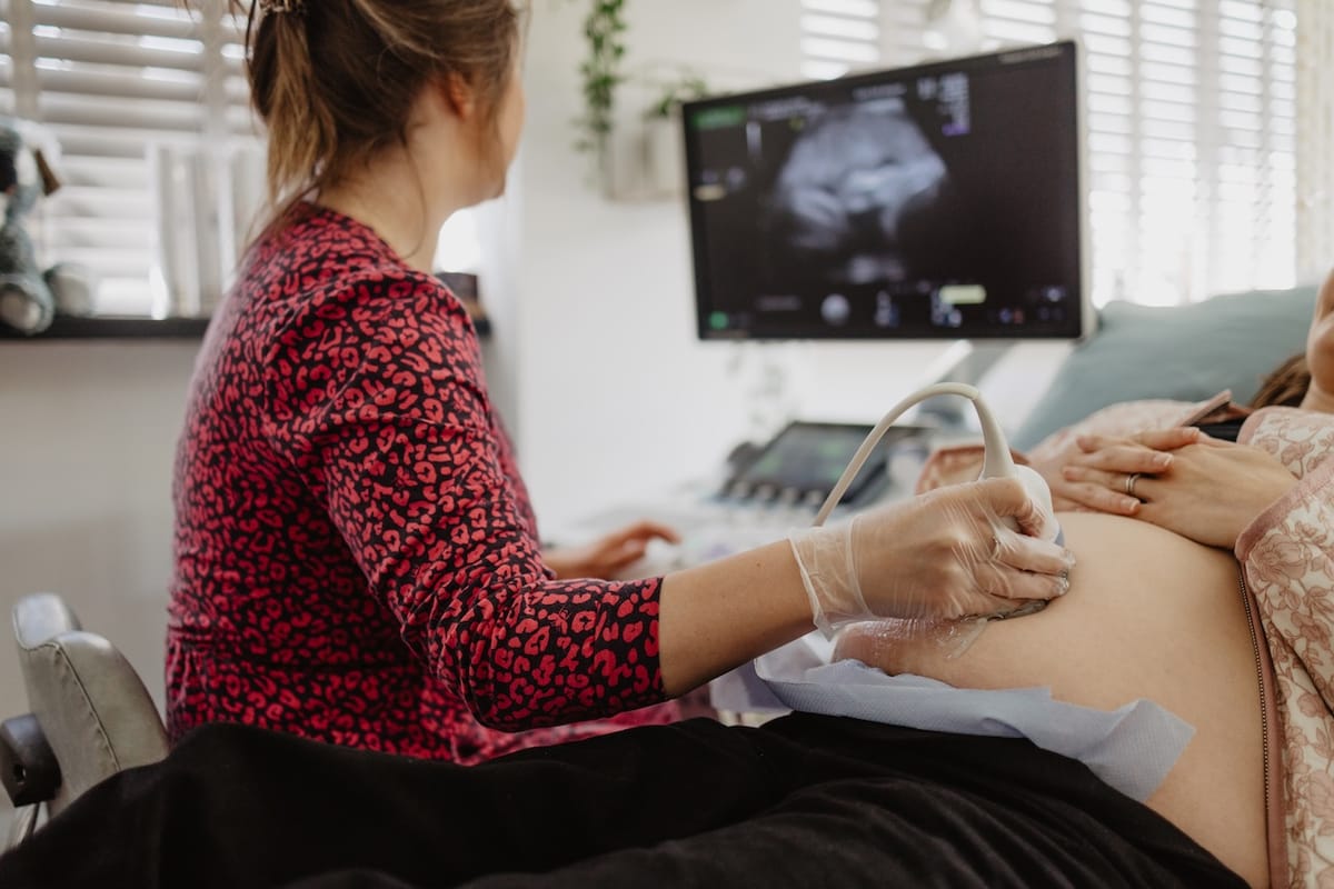 Maria Birch scanning a client at Sneak-A-Peek Ultrasound to illustrate the safety of extra ultrasound scans.